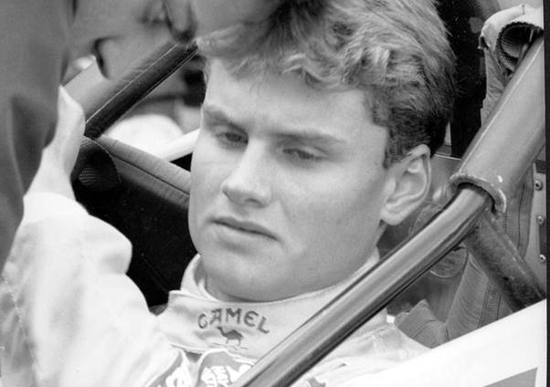 Black and white photo of a young David Coulthard sitting in the Formula Vauxhall Lotus car of Paul Stewart Racing