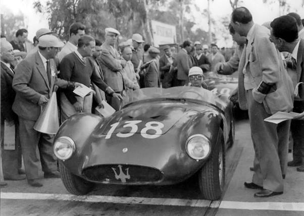 black and white photo of A group of people standing around a 1959 Maserati 6GCS Racing car

