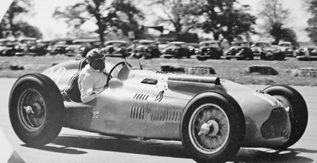 A vintage photo of a person driving a car

Description automatically generated