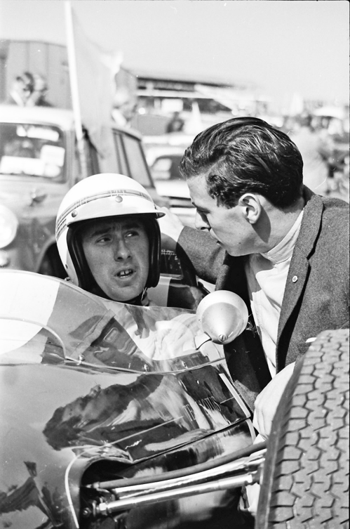 Jackie sitting in a Formula 1 car for the first time. Jim Clark gives him some advice before an impromptu run after practice during the British Grand Prix meeting 1964