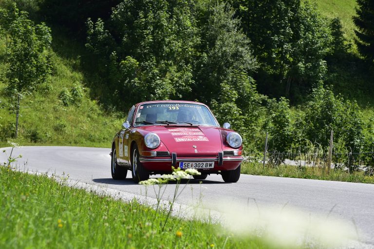 Racing driver Jo Ramirez driving a red Porsche 912 in green forest, our highest placed member